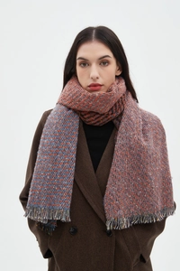 Detailed close-up of heavy knit scarf with orange and blue herringbone pattern and fringes