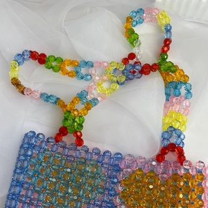 Close-up of colorful handmade beaded tote bag with flower pattern and acrylic beads