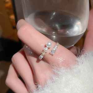 Detail of adjustable gold ring with white pearls and square cubic zirconia stones