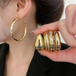 Detailed view of gold pleated earring set featuring twisted hoops and textured designs