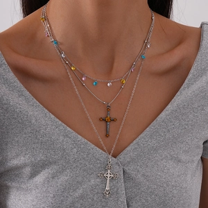Detail of bohemian layered necklace with colorful zircons and engraved cross pendants