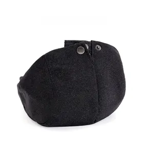 Detail of adjustable metal back buttons on black canvas flat cap for custom fit