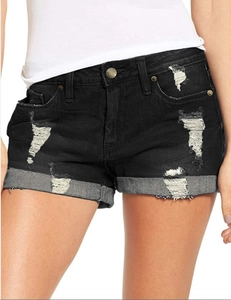 Detalle de pantalones cortos vaqueros negros con bordes deshilachados y talle alto