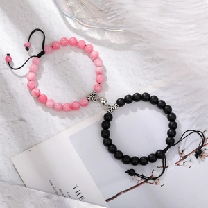 Close-up of magnetic beads bracelets for couples with pink marble and matte black stones