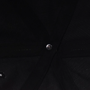 Macro shot of reinforced seams and silver metal rivet inside the black baseball cap crown