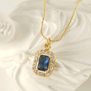 Double-layered gold stainless steel necklace with blue square zircon pendant on white stone