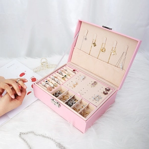 Pink PU leather jewelry box detail with necklace hooks, ring slots, and soft plush background