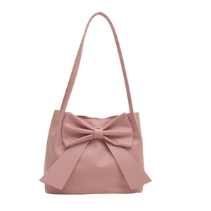 Sac fourre-tout rose avec grand nœud décoratif et longue bandoulière sur fond blanc