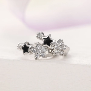 Macro shot of silver ring with stacked black enamel and white zircon star details
