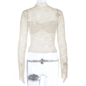 Détail du haut à manches longues en dentelle transparente avec broderies florales délicates