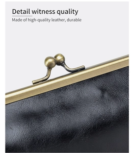 Detailed close-up of vintage brass clasp and premium black leather grain on clutch bag