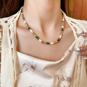 Detailed shot of beaded necklace featuring colorful stones and pearls on model