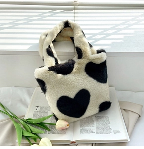 Detail of plush black and white heart patterned handbag in a warm natural light setting