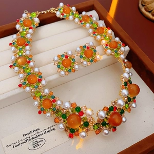 Détail d'un ensemble de bijoux vintage avec pierres orange et perles en coffret