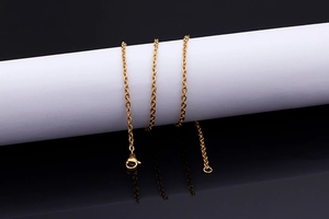 Macro shot of minimalist gold chain necklace with high-gloss finish and lobster clasp
