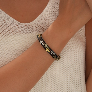Détail d'un bracelet en cuir multicouche avec croix métalliques porté par un mannequin