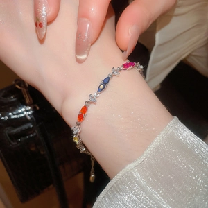 Detail of colorful marquise-cut gems on a silver-tone bracelet worn on wrist