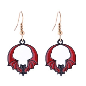 Detail view of red and black enamel bat earrings with gold hooks on white background