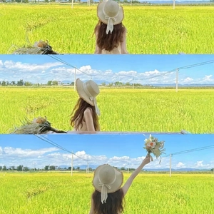 Women's wide brim straw sun hat with ribbon bow in a scenic outdoor meadow setting