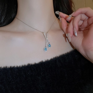Détail du collier en Y argenté avec des pendentifs en zircon bleu étincelants en forme de poire