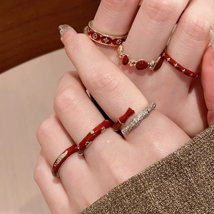 Detail of red enamel and 14k gold plated stacking rings set on a female hand
