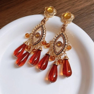 Detailaufnahme von böhmischen Schlangenohrringen in Gold mit bernsteinfarbenen Perlen