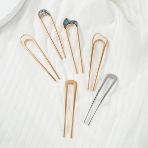 Detail view of U-shaped hair pins with iridescent shell and marble patterns on metal