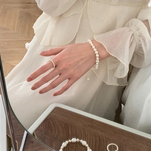 Macro shot of elegant natural freshwater pearl bracelet and ring set on model's hand