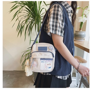 Détail d'un sac bandoulière en toile style japonais avec écussons et poche transparente