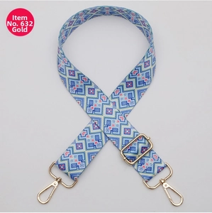 Detail of blue, red, white geometric woven bag strap with gold metal spring hooks