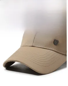 Close-up of khaki baseball cap featuring fine stitching and a shield metal emblem