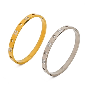 Detail of gold and silver stainless steel bangles with star cutouts and crystals