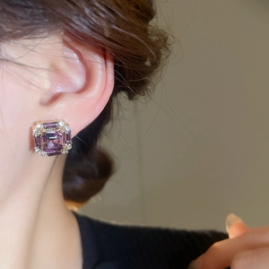 Close-up of radiant cut purple gemstone stud earrings with white zircon accents