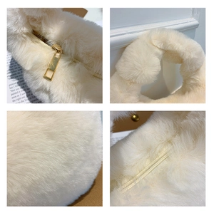 Detail shot of the plush beige bag fabric and gold metal zipper with soft fuzzy handle
