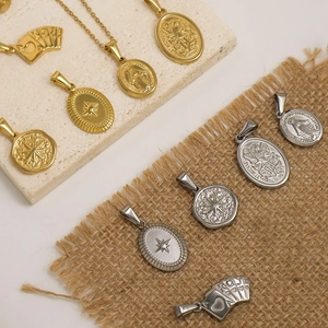 Vintage gold and silver stainless steel Saint Michael heart necklaces on stone background