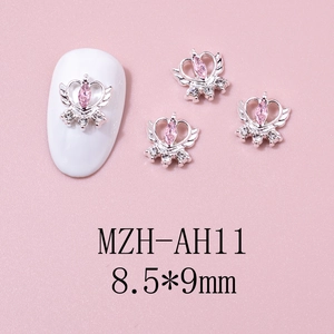 Detailed view of silver winged crown nail charms with pink marquise stone and zircon accents
