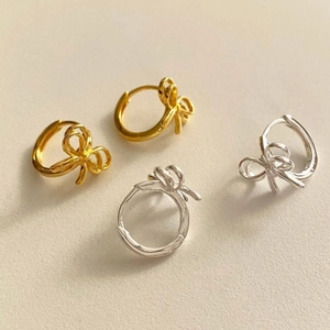 Macro detail of S925 sterling silver bowknot hoop earrings in gold and silver finish