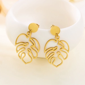Minimalist gold-plated hollow monstera leaf earrings on white ceramic holder