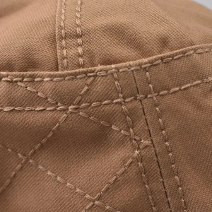 Detailed macro view of brown canvas fabric with diamond lattice stitching and precise seams