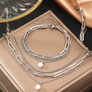 Three-layer silver chain necklace featuring white pearl pendants and paperclip links