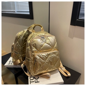 Detailansicht eines goldenen gesteppten Rucksacks mit Rautenmuster und Textur