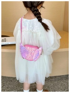 Pink sequin angel wing bag shown on a young girl wearing a white tulle dress