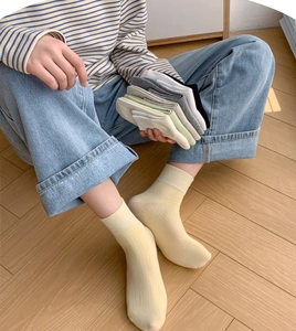 Close-up of ribbed cotton crew socks in pastel colors on warm wooden background