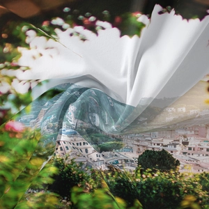 Detailed view of silky fabric showing coastal town landscape print and soft draped texture