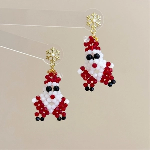 Detailed view of handmade beaded Santa Claus earrings with golden snowflake studs