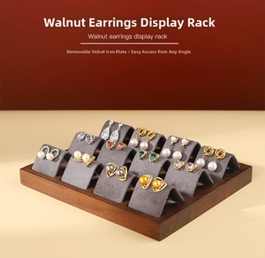 Macro view of walnut wood base with removable grey flocked earring display inserts