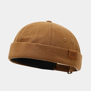 Détail d'un bonnet docker marron avec écusson en cuir DAD et œillets de ventilation