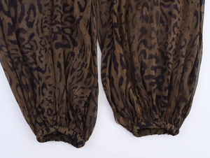 Dettaglio dei pantaloni a sbafo con stampa leopardata, polsini elastici e tessuto velato