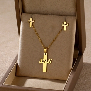 Detailed view of golden Jesus cross necklace and earrings set in a brown jewelry box