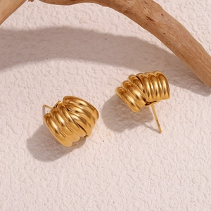 Macro shot of 18K gold plated stainless steel triple layered earrings on a white stone base